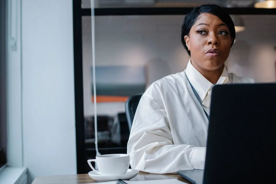 A thoughtful professional working at a desk in an office