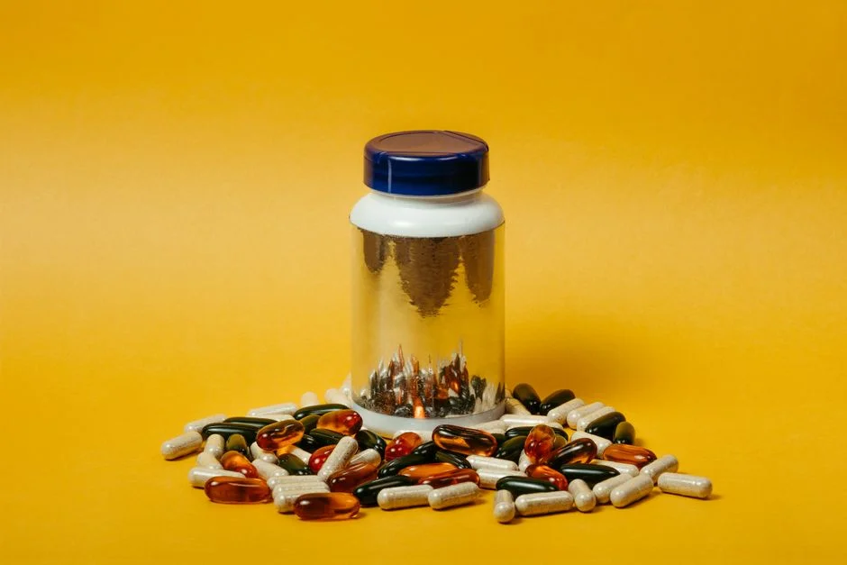 Multi-colored supplement capsules and a bottle on a table