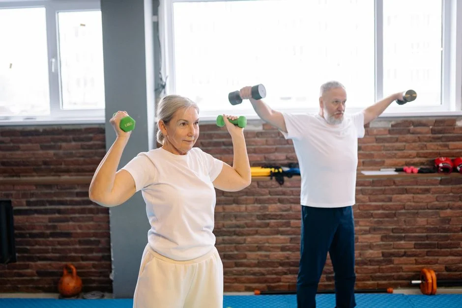 A man and woman lifting dumbbells together in a strength session