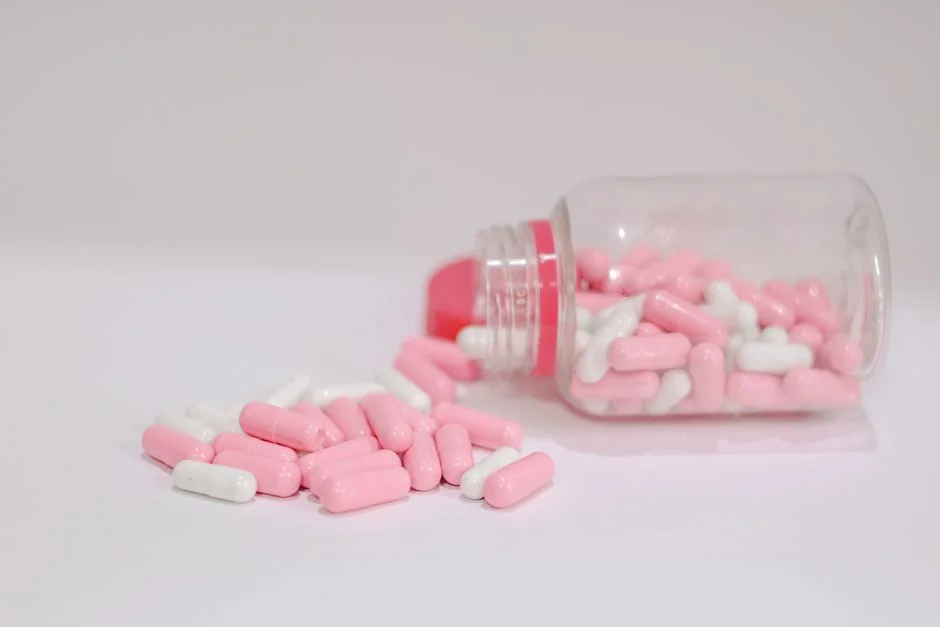 Pink and white pills spilled from an open bottle