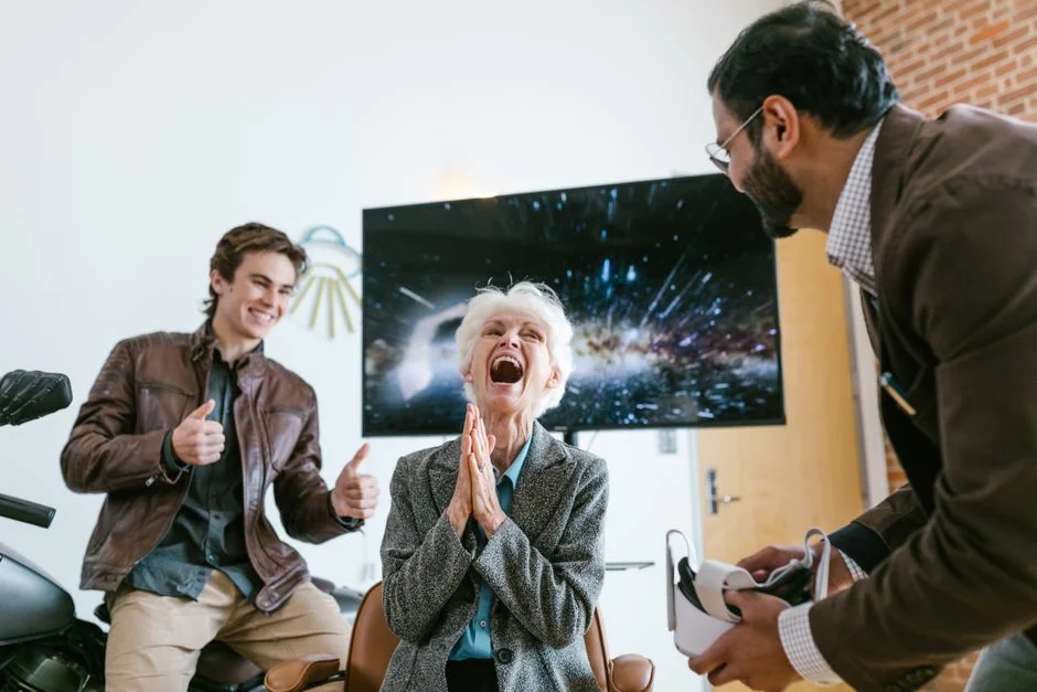 Smiling older woman with white hair beside a man holding a virtual reality headset