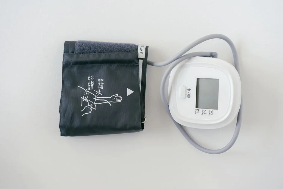 Home blood pressure monitor with arm cuff and digital display on a plain white surface