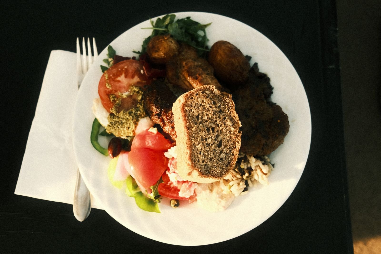 Overhead view of a colorful Mediterranean meal with bread and vegetables